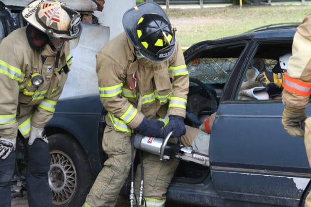 firefighters using jaws of life to get someone out of a car